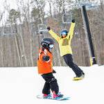 A guest snowboarding with an instructor at Massanutten Resort
