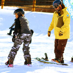 A guest snowboarding with an instructor at Massanutten Resort